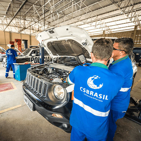 Funcionários da CS Brasil trabalhando com veículos estacionados